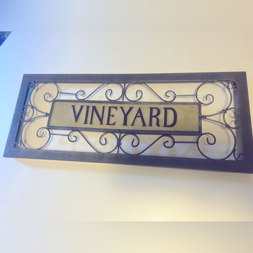 Metal decor that says, “Vineyard”